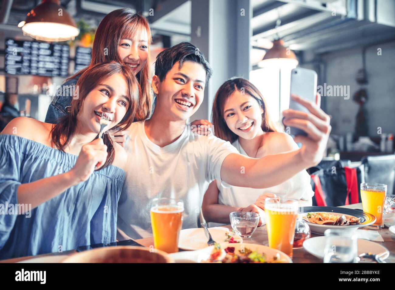 des jeunes heureux assis au restaurant et prendre selfie Banque D'Images