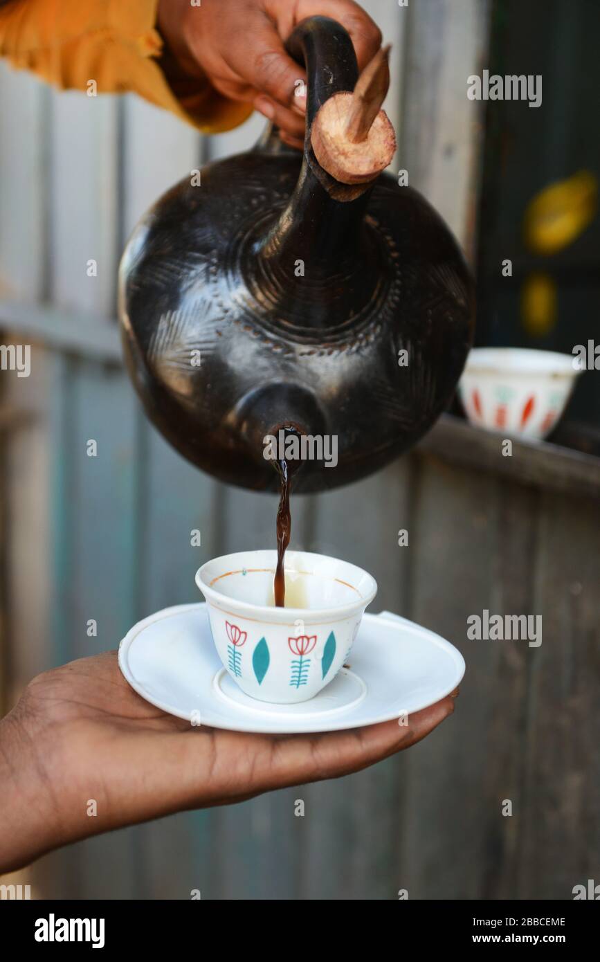 Une femme éthiopienne qui verse du café éthiopien traditionnel. Banque D'Images