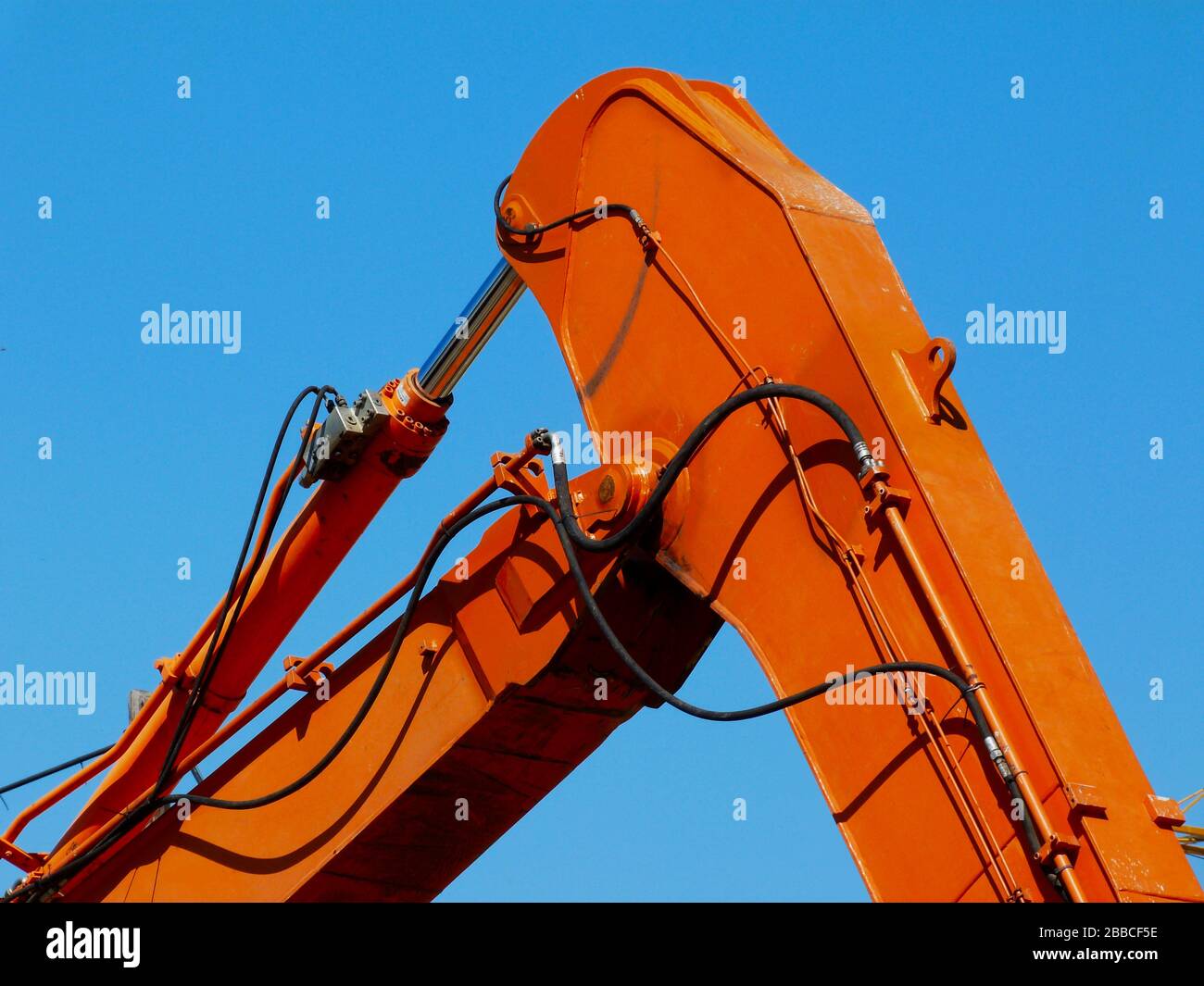 détail de la fermeture des bras de la machine hydraulique en acier. couleur orange. flexibles en caoutchouc pour fluides hydrauliques haute pression, bouteilles et tubes. industrie de la construction Banque D'Images