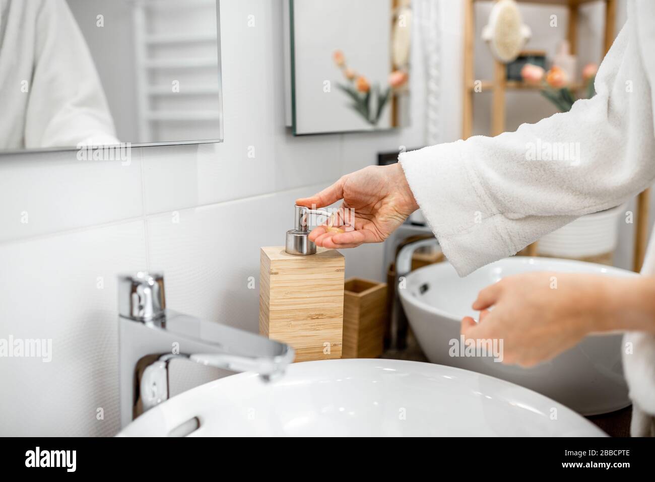 Femme appliquant du savon sur les mains à l'aide d'un bacher dans la salle de bains, gros plan Banque D'Images