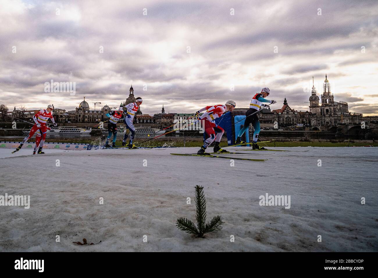 Des hommes qui font des courses à la FIS cross-country ski sprint World Cup sur les rives de la rivière Elbe, la ligne d'horizon de la ville baroque au loin Banque D'Images