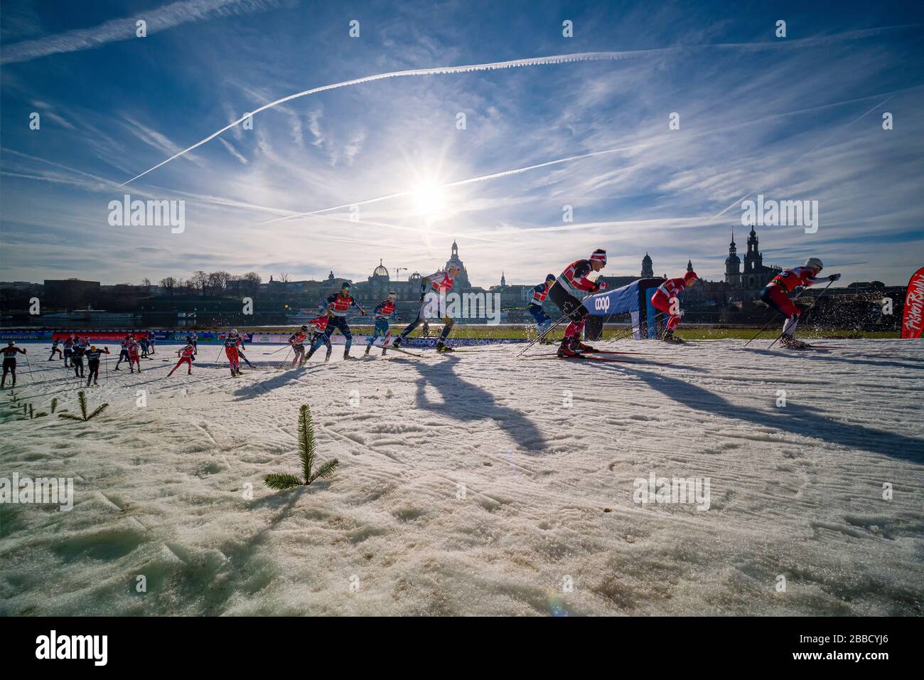 Des hommes qui font des courses à la FIS cross-country ski sprint World Cup sur les rives de la rivière Elbe, la ligne d'horizon de la ville baroque au loin Banque D'Images