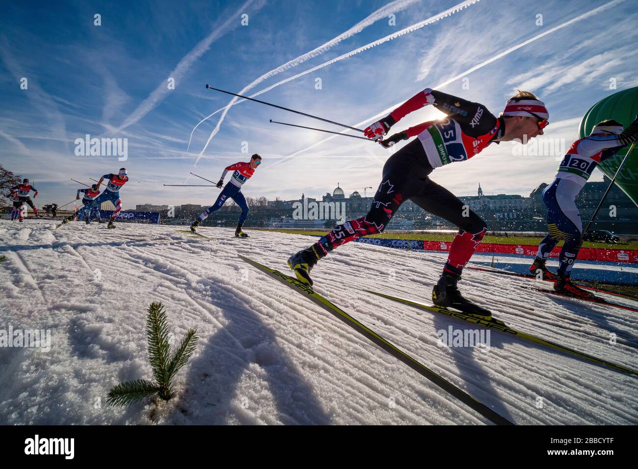 Des hommes qui font des courses à la FIS cross-country ski sprint World Cup sur les rives de la rivière Elbe, la ligne d'horizon de la ville baroque au loin Banque D'Images