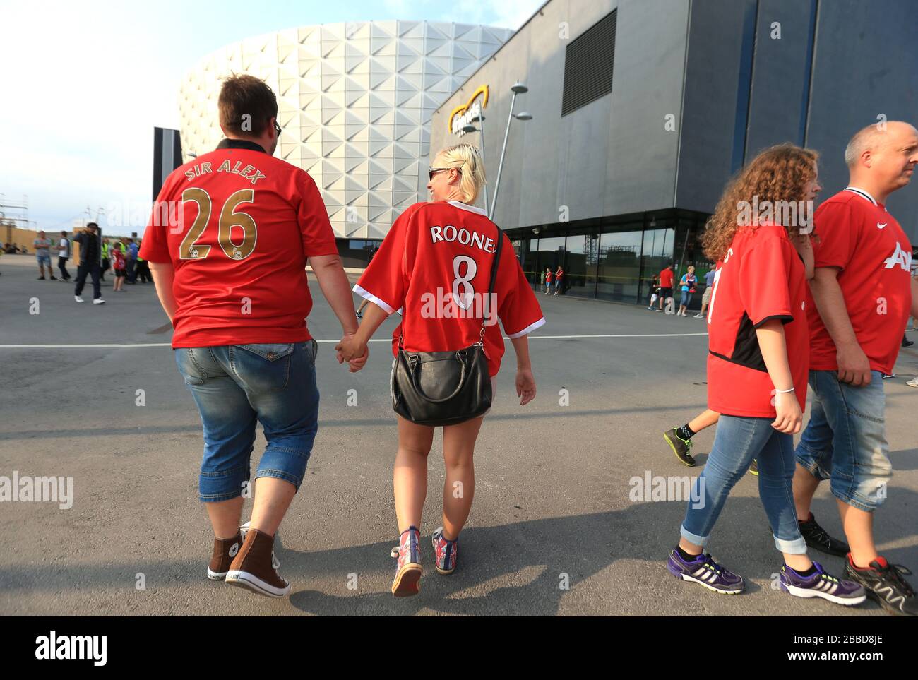 Les fans de Manchester United avec les noms « ir Alex » et « Rooney » au dos de leurs chemises marchent vers le stade Friends Arena Banque D'Images