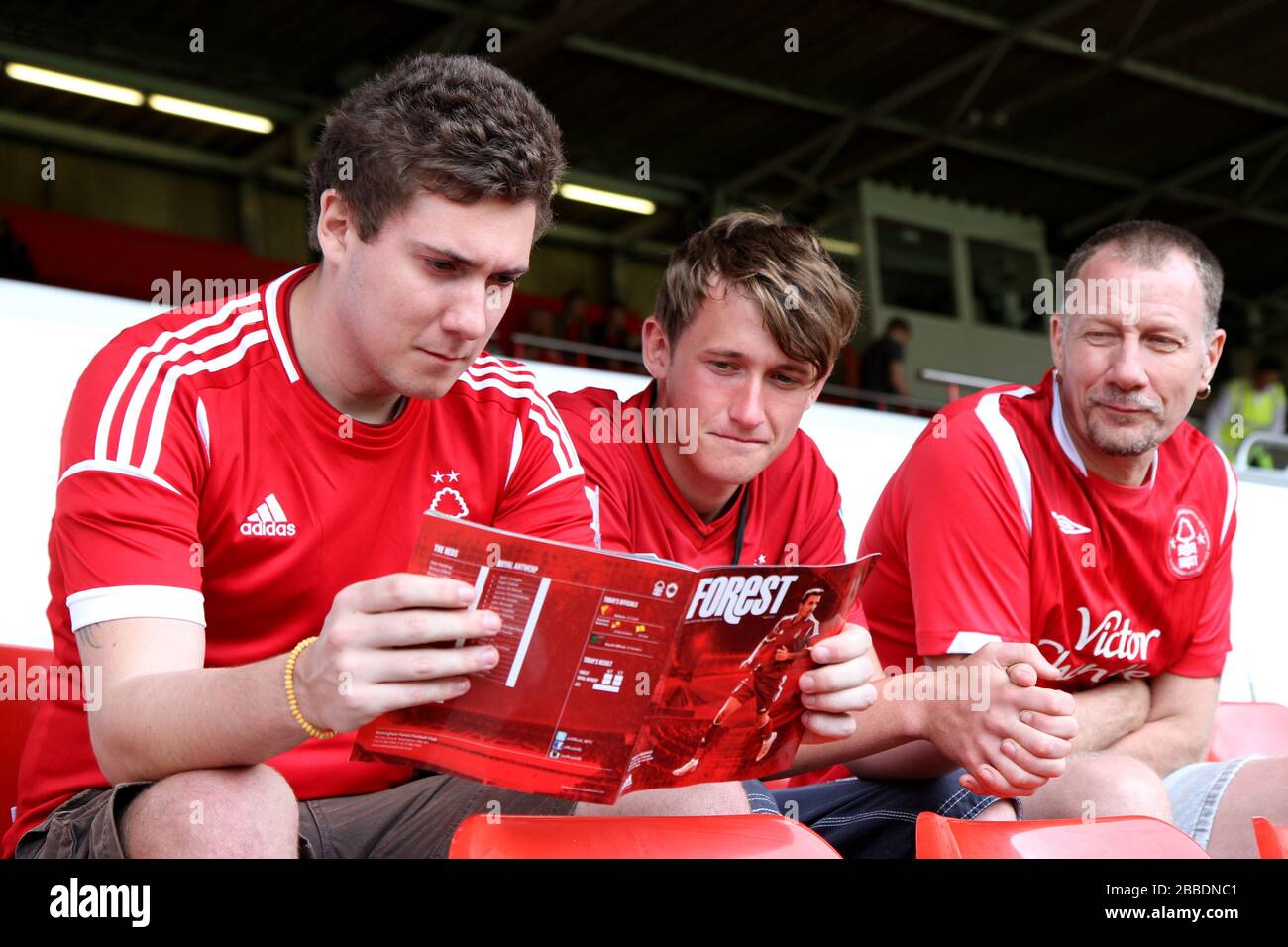 Les fans lisent le programme match day Banque D'Images