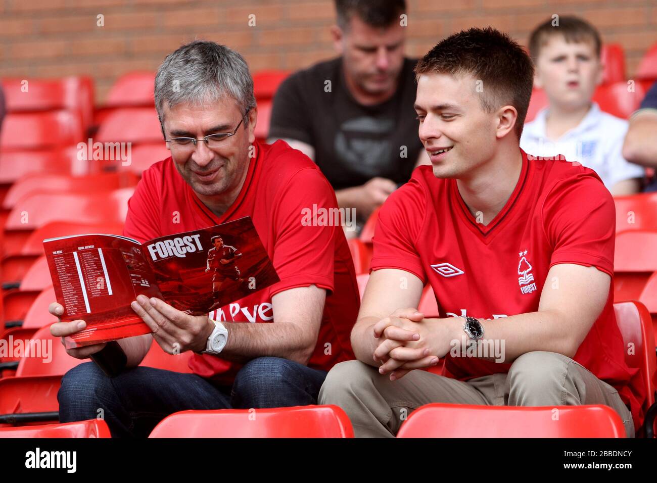 Les fans lisent le programme match day. Banque D'Images