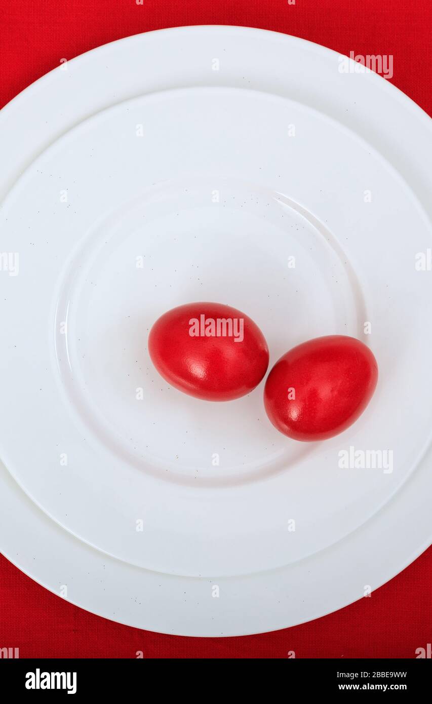 Table de Pâques, place. Œufs rouges sur une plaque blanche, nappe rouge, vue sur le dessus. Table de célébration orthodoxe chrétienne de Pâques Banque D'Images