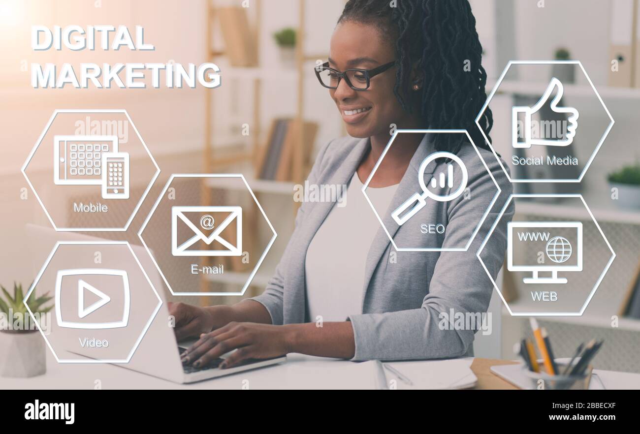Une dame d'affaires afro-américaine travaillant au bureau, collage avec des icônes de marketing numérique sur l'écran virtuel Banque D'Images