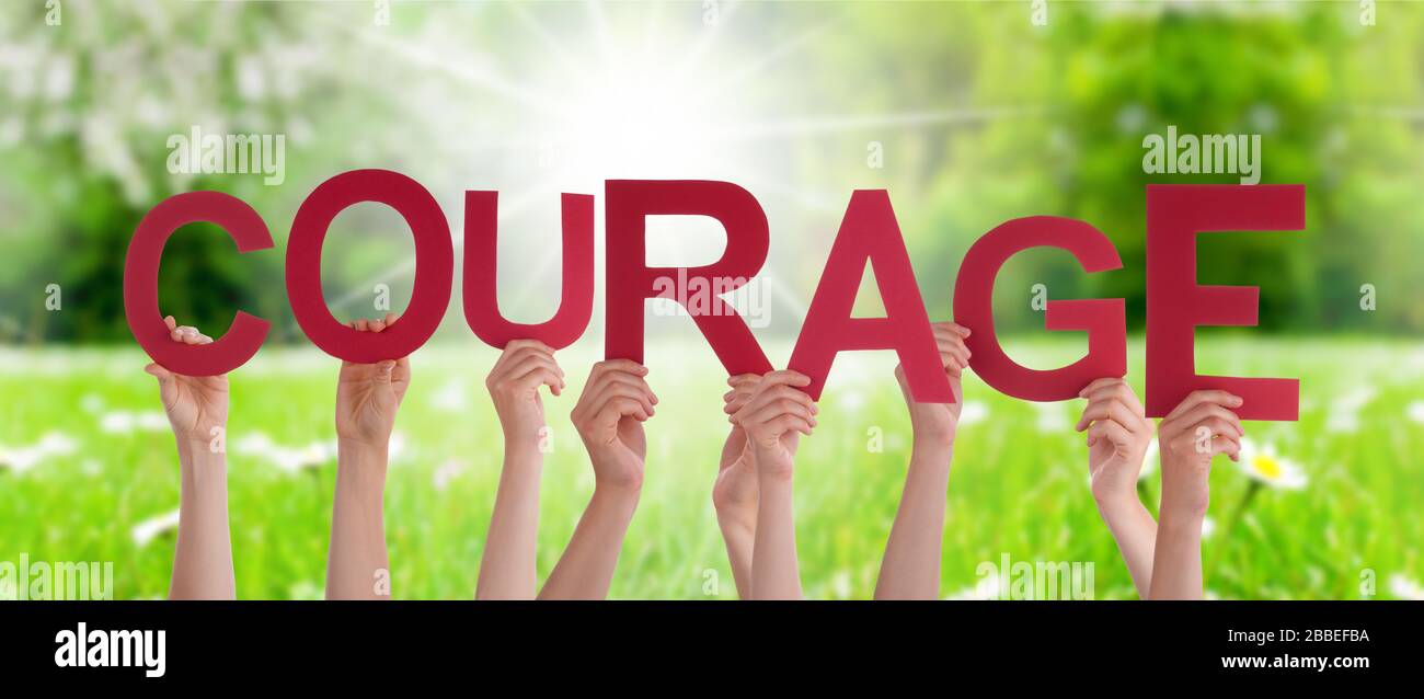Les gens mains tenir mot courage signifie ne pas abandonner, Grass Meadow Banque D'Images