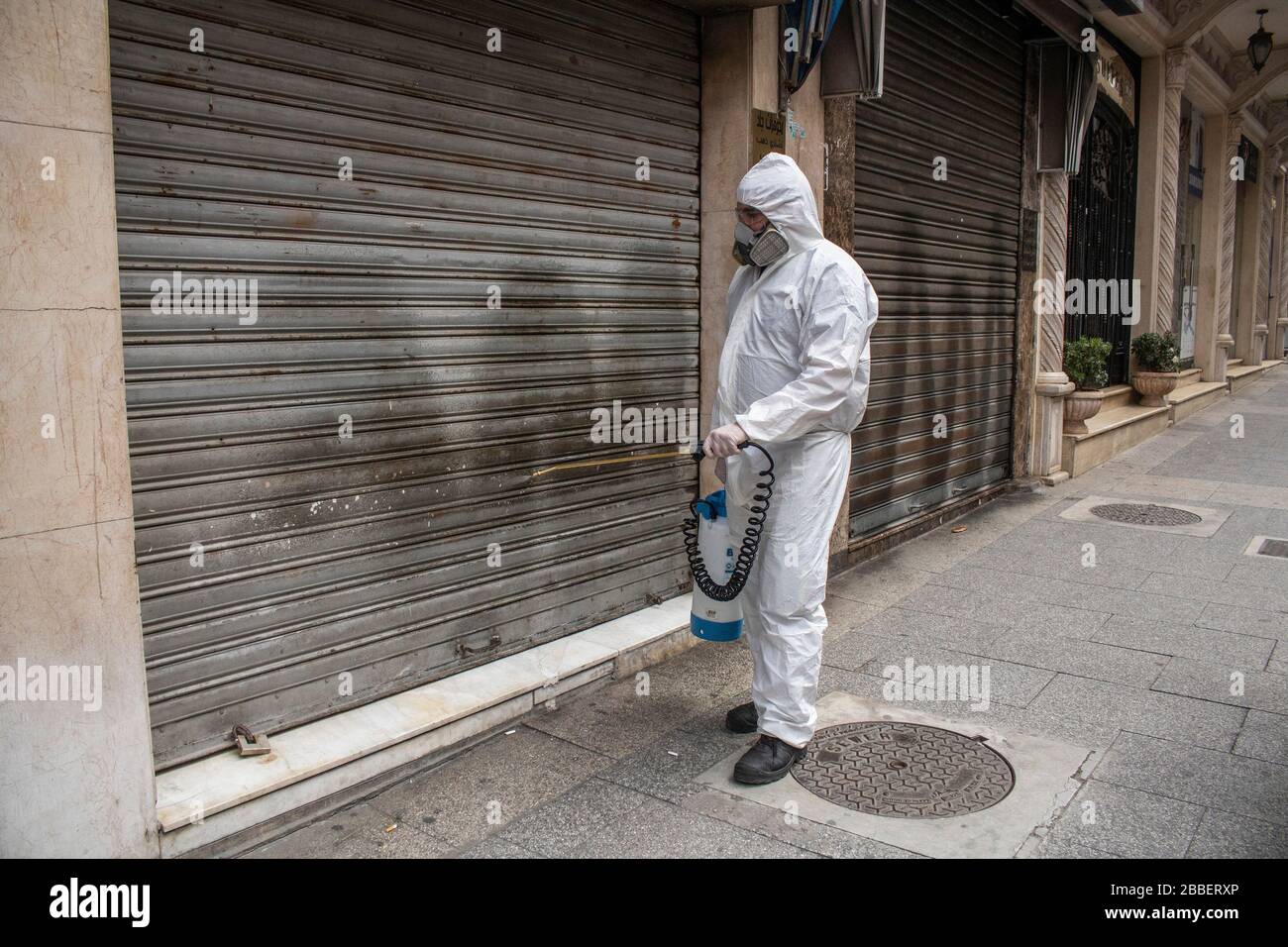 Beyrouth, Liban. 31 mars 2020. Un professionnel de l'entretien portant des lunettes de protection et un costume de hazmat vaporise du désinfectant autour des locaux de l'atelier, dans la rue Hamra de Beyrouth, comme mesures de protection contre la propagation du coronavirus nouveau covid-19. Crédit: amer ghazzal/Alay Live News Banque D'Images