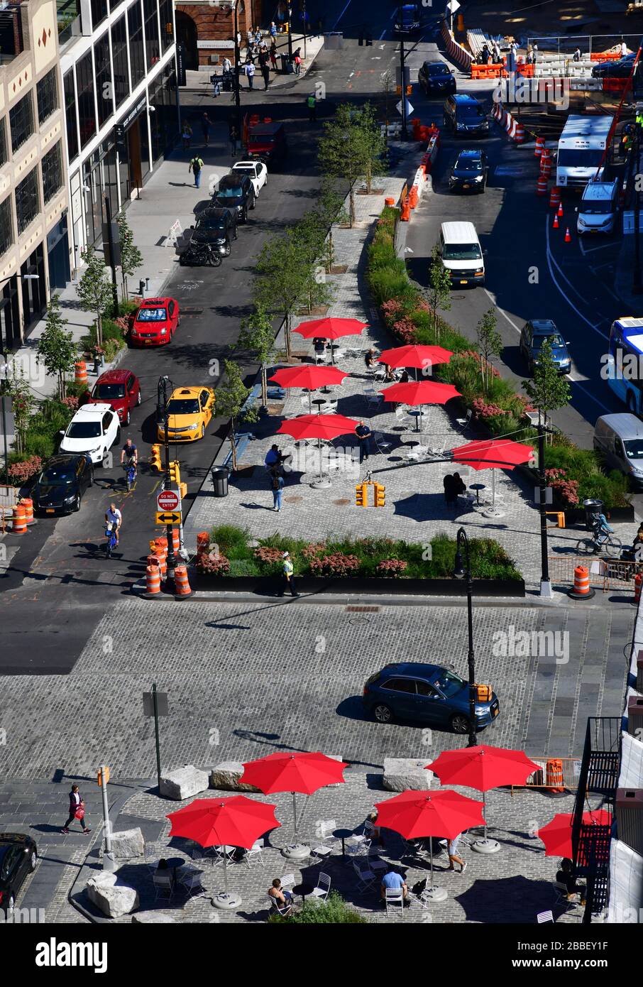 New York, États-Unis-sept 2019: Vue à grand angle de la place avec parasols rouges au croisement de la 9ème Avenue et de la 14ème rue Banque D'Images