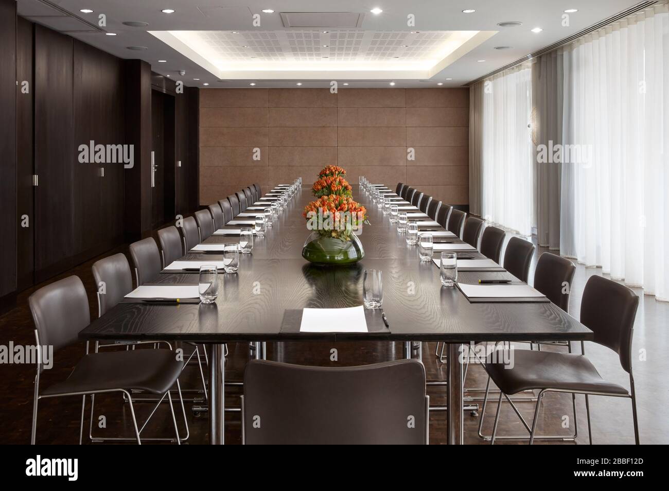 Salle de conférence avec éclairage LED au plafond, la rangée de chaises  marron, avec scène et écran vide pour réunions d'affaires, conférences,  cours de formation, modèle utilisé Office Design élégant Photo Stock -