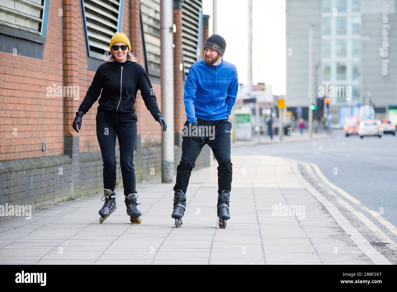Glasgow, Royaume-Uni. 30 mars 2020. Photo : un couple a vu le patinage en ligne pendant son régime d'exercice d'une journée pendant le Lockdown de Coronavirus à Glasgow. Comme les rues sont maintenant très calmes, cela donne lieu à des conditions idéales pour le patinage car tous les trottoirs et les surfaces sont vides. Crédit : Colin Fisher/Alay Live News. Banque D'Images