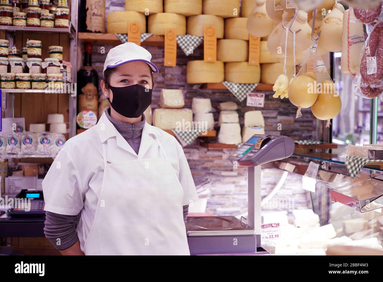 Un assistant de magasin de fromage portant un masque de protection covid-19. Milan, Italie - mars 2020 Banque D'Images