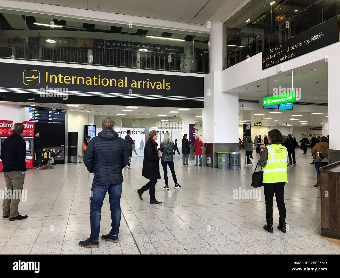 Les parents de citoyens britanniques qui reviennent du Pérou à l'aéroport de Gatwick attendent leur arrivée tout en gardant deux mètres à l'écart. Banque D'Images