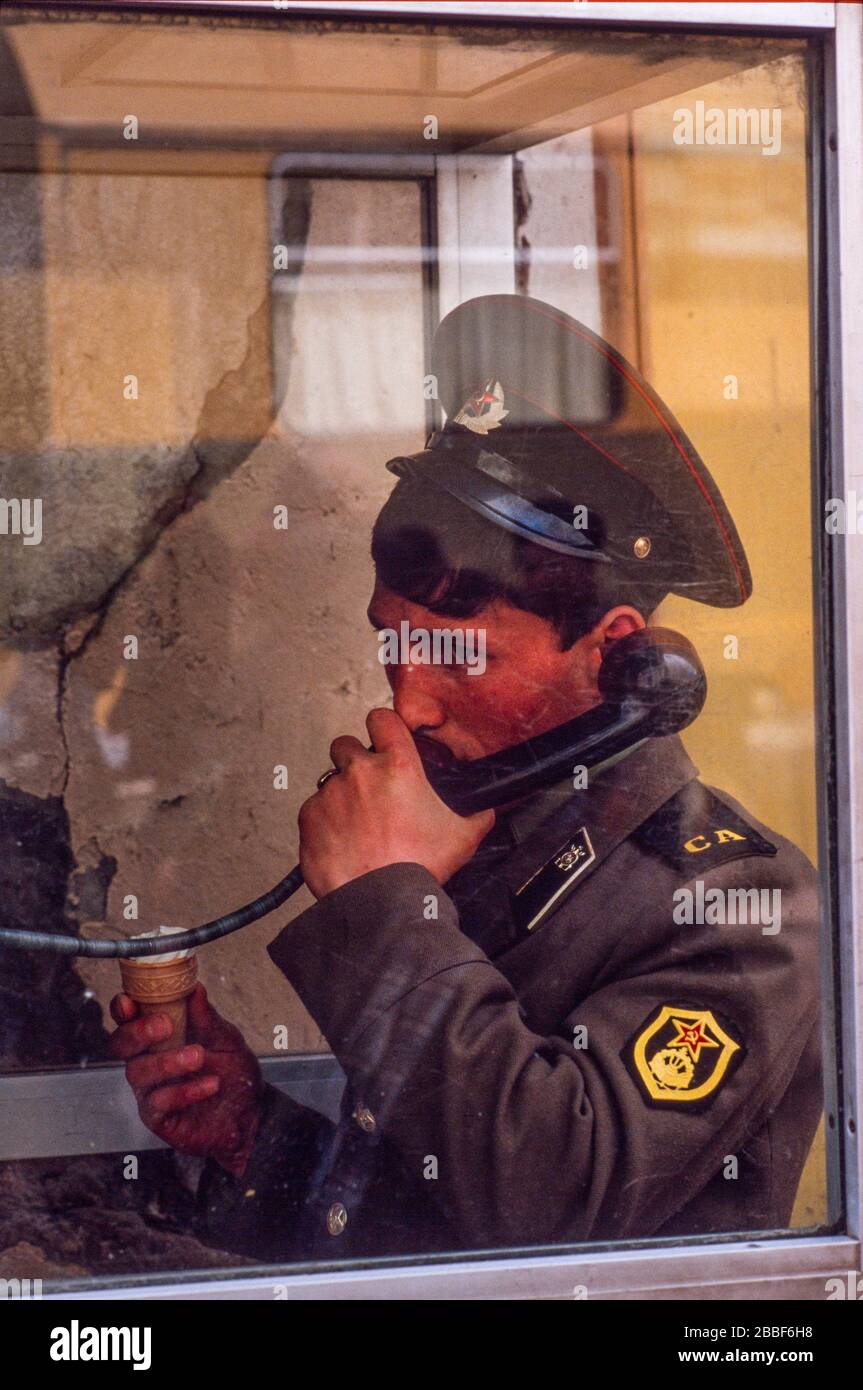 Un jeune soldat russe fait un appel téléphonique tout en mangeant une glace, Moscou, mai 1990 Banque D'Images
