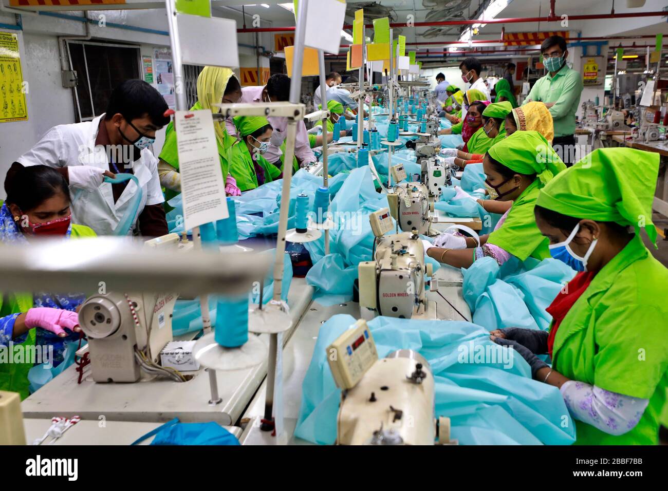 Dhaka, Bangladesh - 31 mars 2020: Travailleurs produisant des équipements de protection individuelle (EPI) pour les professionnels de la santé dans une usine de vêtements du groupe Urmi Banque D'Images