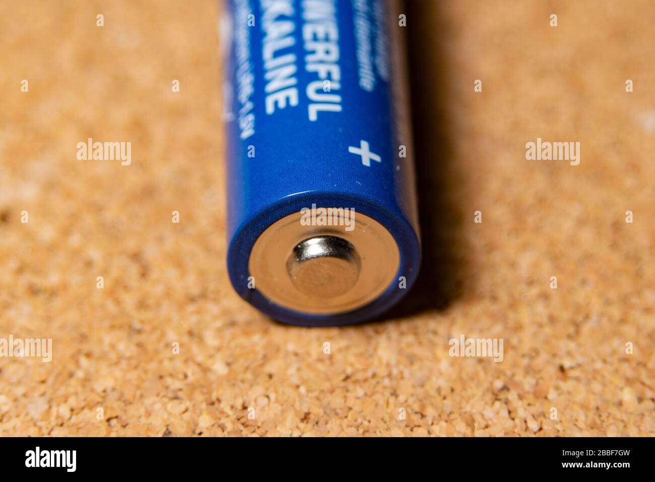 batterie bleue posée en position positive sur le panneau en liège Banque D'Images