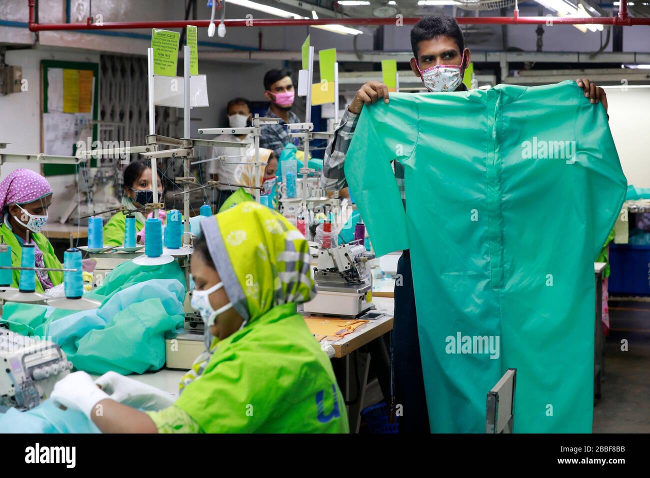 Dhaka, Bangladesh - 31 mars 2020: Travailleurs produisant des équipements de protection individuelle (EPI) pour les professionnels de la santé dans une usine de vêtements du groupe Urmi Banque D'Images
