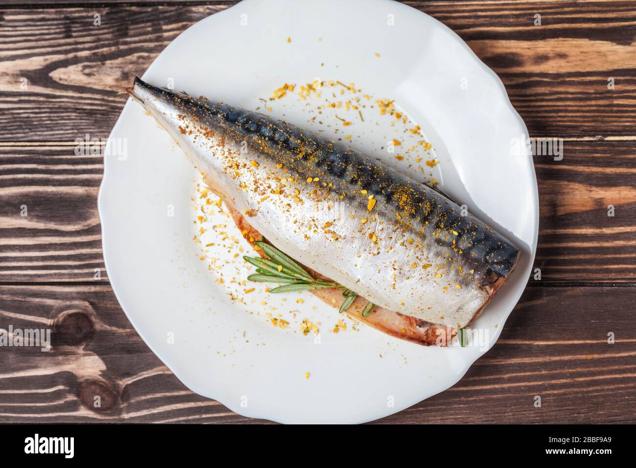 Maquereau mariné dans une plaque blanche. Poisson cru non préparé. Spécialités de fruits de mer traditionnelles, concept de saine alimentation. Sur le fond d'un plan d'examen en bois Banque D'Images