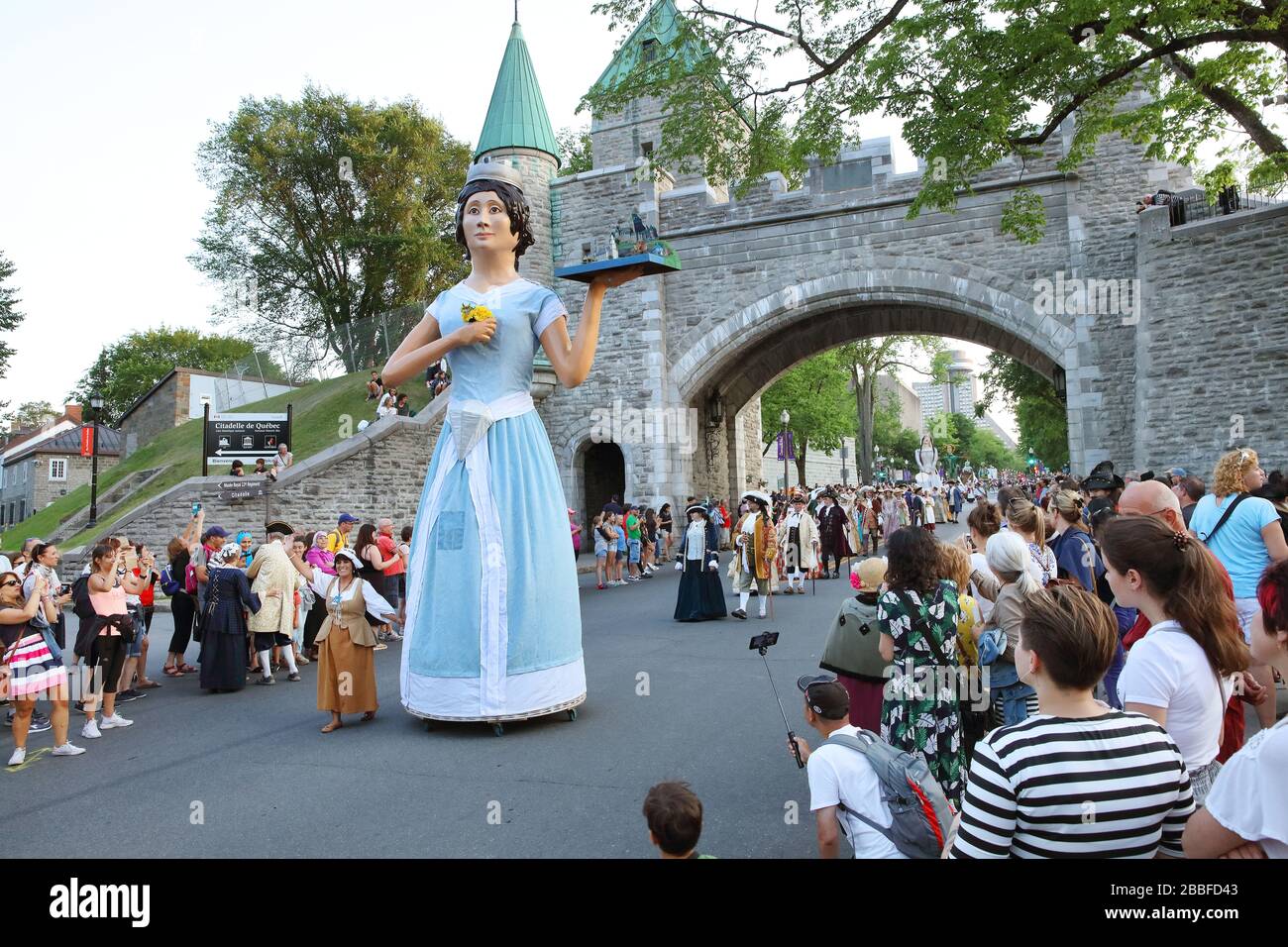 Défilé avec des participants en costumes d'époque et des « géants » symbolisant des personnages ou des lieux historiques lorsque Québec faisait partie de la Nouvelle-France (fin des années 1800). Le géant de la photo est Dame Cap-Diamant (Lady Cape Diamond) et, en arrière-plan, porte Saint-Louis, Québec, province de Québec, Canada Banque D'Images