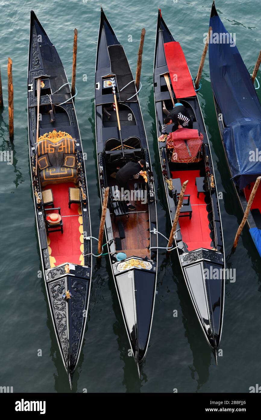 Venise, Italie-février 2020 ; vue rapprochée et à angle élevé d'un certain nombre de gondoles vénitiennes traditionnelles essuyées par les gondoliers Banque D'Images