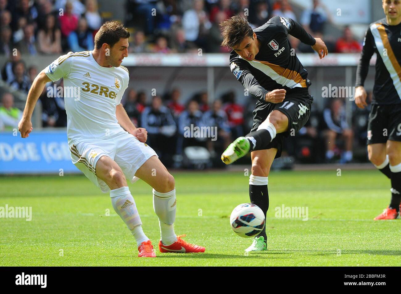 Bryan Ruiz (à droite) de Fulham emmène le ballon à travers la défense de Swansea puis met à mal le tir sur le but pendant le match de la Ligue Premier Barclays au Liberty Stadium, Swansea. Banque D'Images