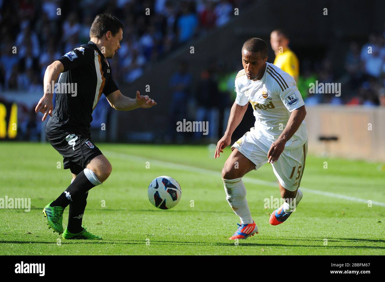 Wayne Routledge de Swansea (à droite) passe le ballon devant Sasha Riether pendant le match de la Barclays Premier League au Liberty Stadium, Swansea. Banque D'Images