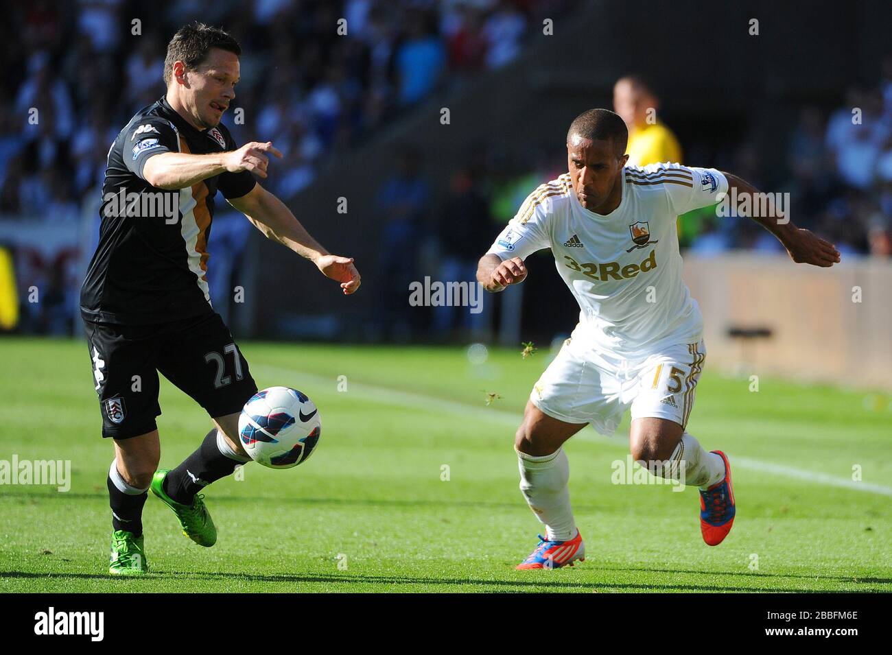 Wayne Routledge de Swansea (à droite) passe le ballon devant Sasha Riether pendant le match de la Barclays Premier League au Liberty Stadium, Swansea. Banque D'Images