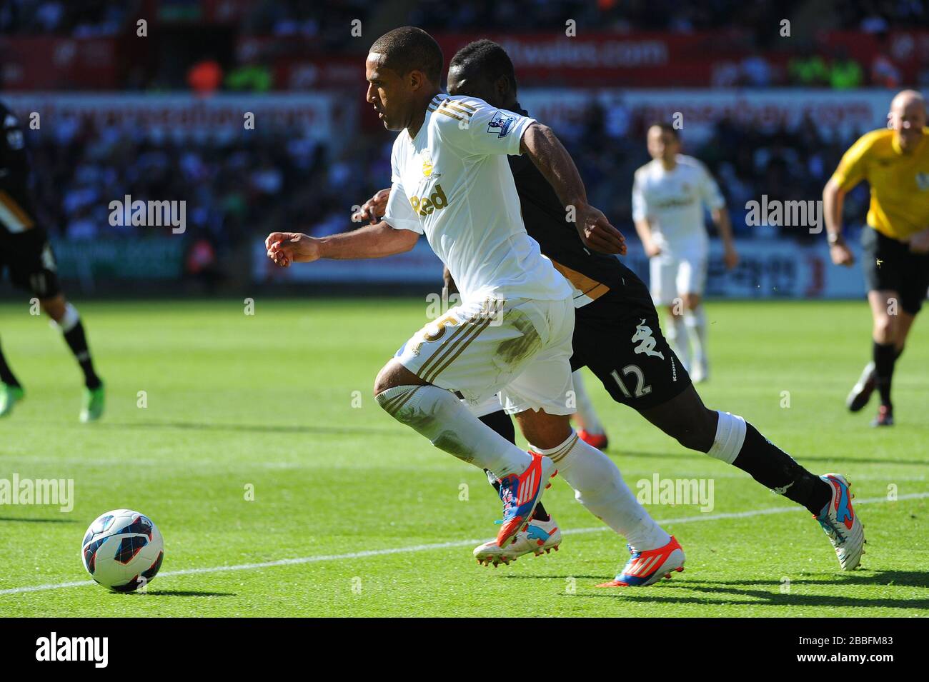 Wayne Routledge de Swansea prend le ballon autour d'Emmanuel Frimpong pendant le match de la Barclays Premier League au Liberty Stadium, Swansea. Banque D'Images
