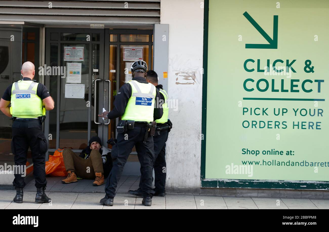 Birmingham, West Midlands, Royaume-Uni. 31 mars 2020. Les policiers parlent à un homme assis dans une porte de magasin du centre-ville de Birmingham pendant le verrouillage pandémique de Coronavirus. Credit Darren Staples/Alay Live News. Banque D'Images