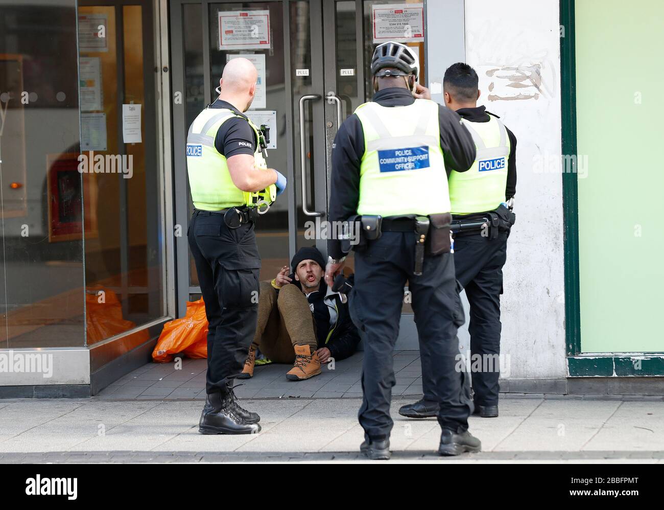 Birmingham, West Midlands, Royaume-Uni. 31 mars 2020. Les policiers parlent à un homme assis dans une porte de magasin du centre-ville de Birmingham pendant le verrouillage pandémique de Coronavirus. Credit Darren Staples/Alay Live News. Banque D'Images