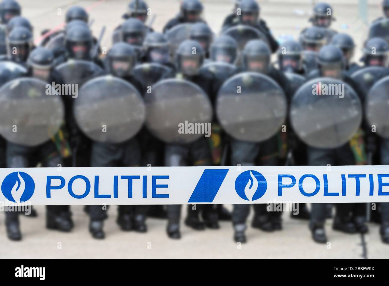 Ruban politié / policier devant l'escadron belge de riot formant une barrière protectrice avec des boucliers de riot en Belgique Banque D'Images