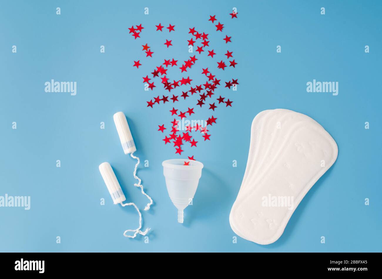 Tampon sanitaire, coupe menstruelle et tampons sur fond bleu. Concept d'hygiène féminine pendant la menstruation. Banque D'Images