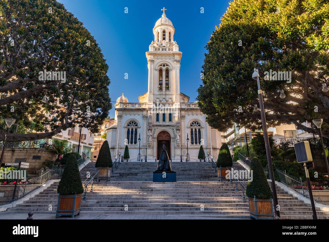 Monaco, Monte Carlo, 25 décembre 2019: L'église catholique Église Saint-Charles au coucher du soleil, escaliers, arbres verts, sans peuple Banque D'Images