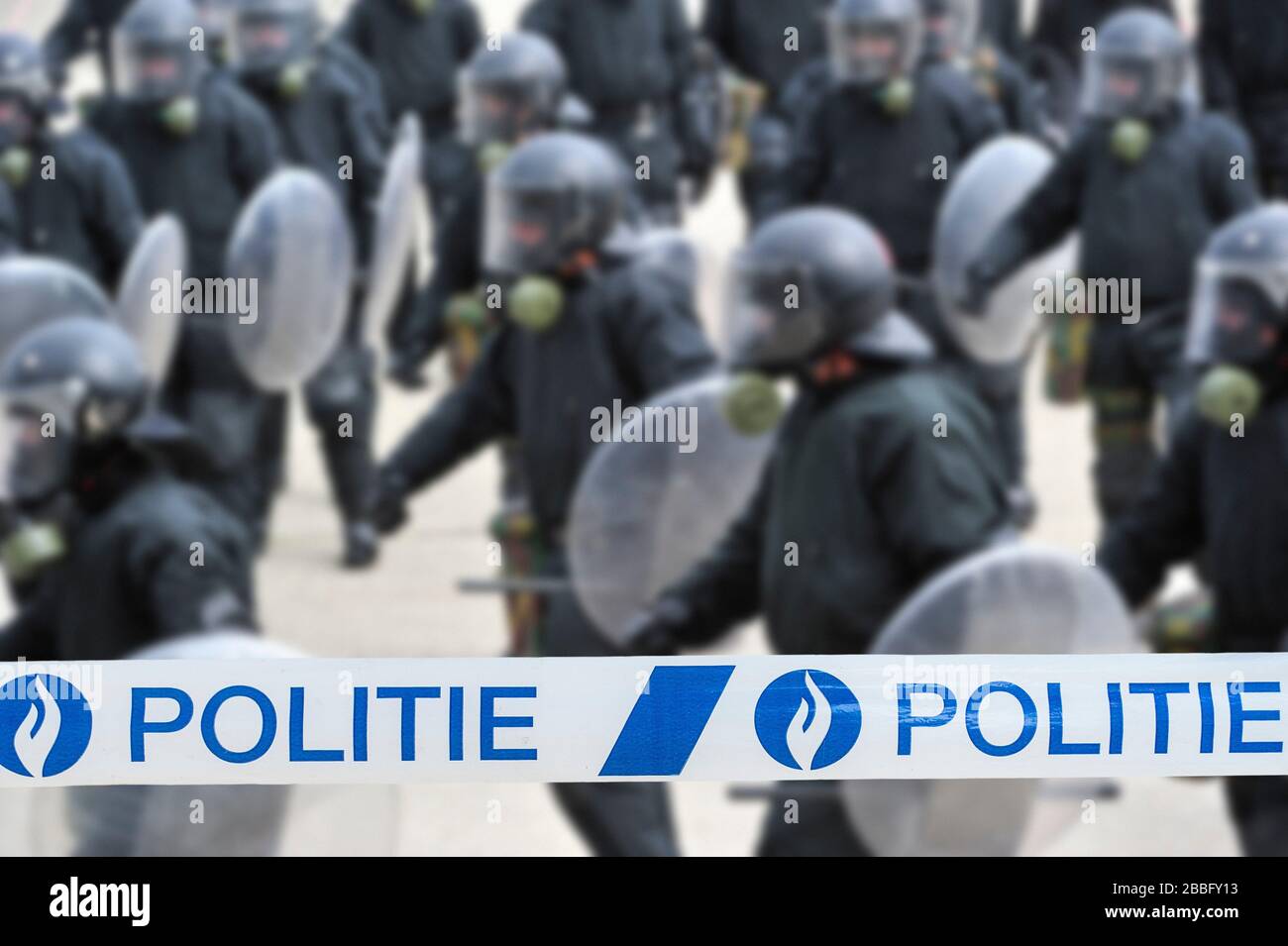 Ruban politié / policier devant l'escadron belge de riot formant une barrière protectrice avec des boucliers de riot en Belgique Banque D'Images