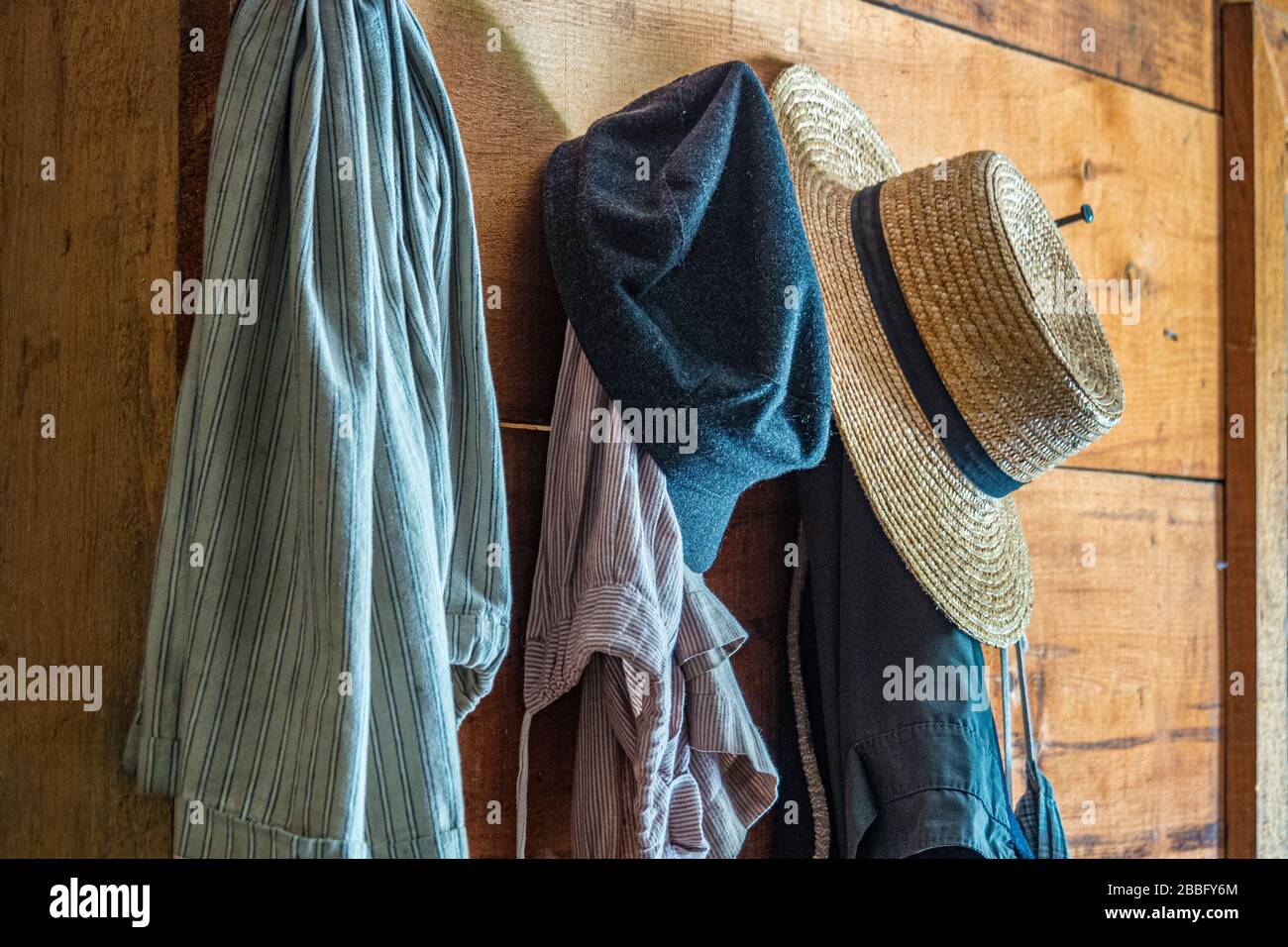 Vieux chapeaux et vêtements accrochés sur un mur en bois Banque D'Images