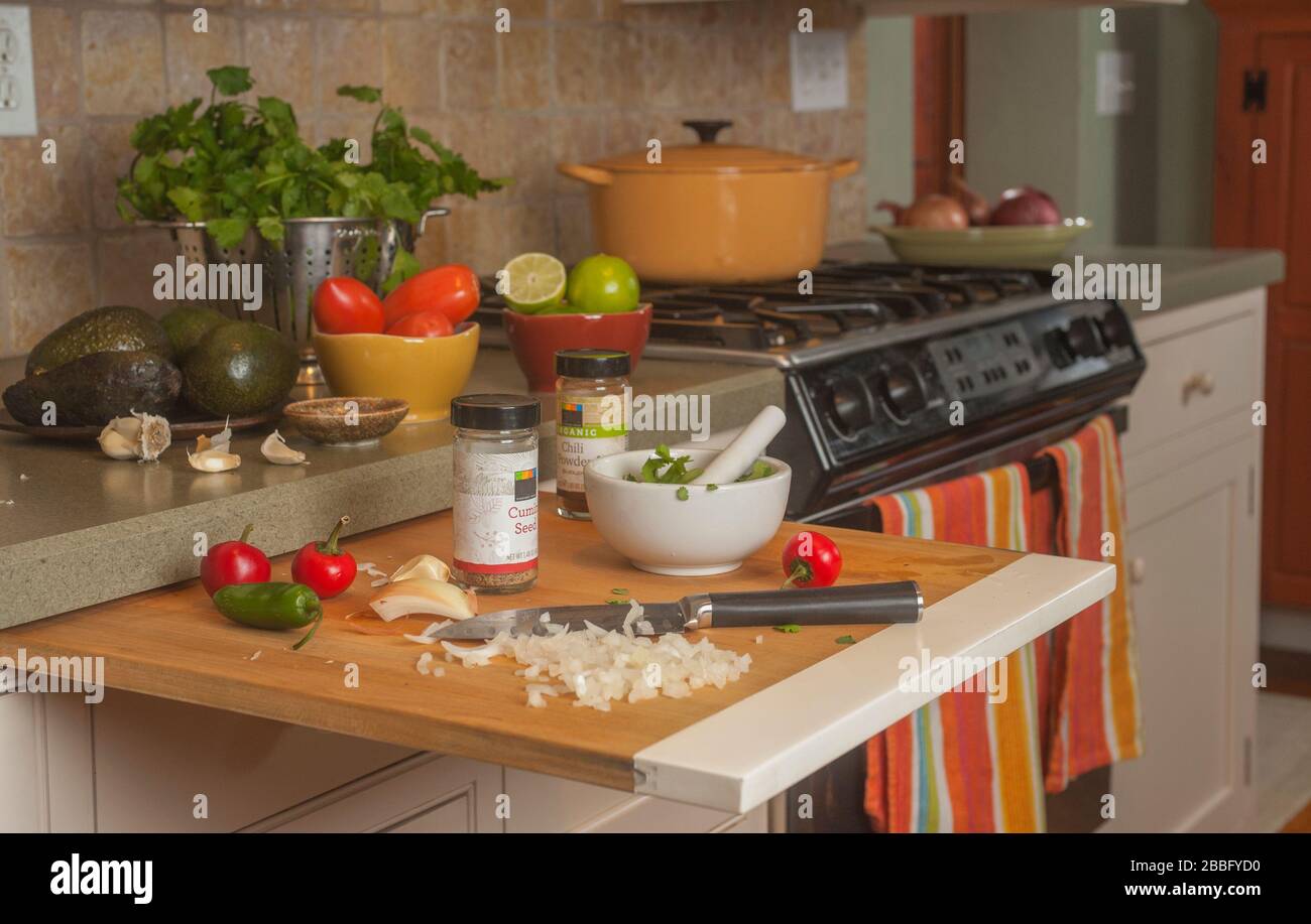 Ingrédients pour la fabrication de guacamole dans la cuisine par cuisinière à gaz. Banque D'Images