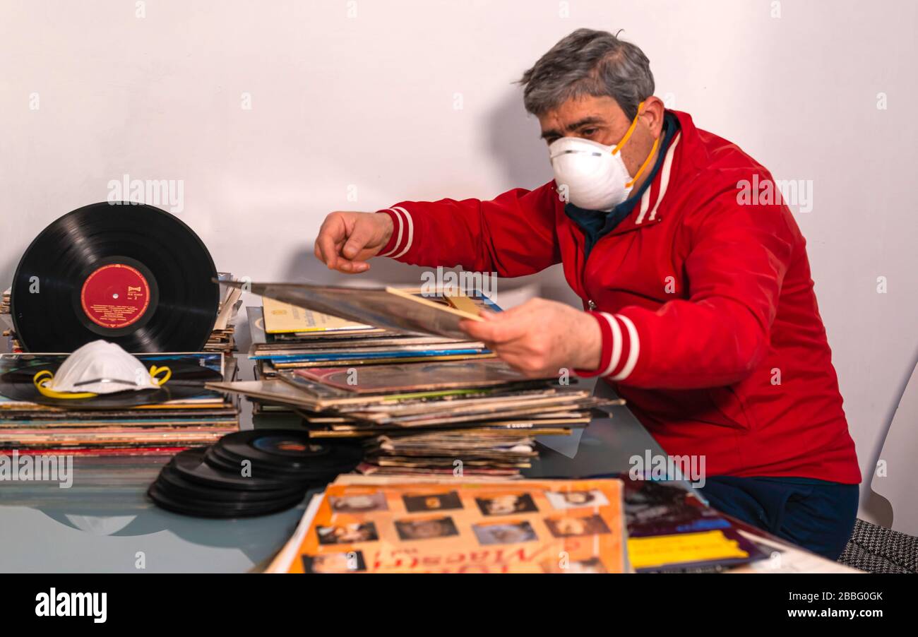 Modugno, Italie - 12 mars 2020: Au foyer pour la pandémie de coronavirus quarantaine COVID-19. Passionné audiophile commande sa collection de vinyle Banque D'Images