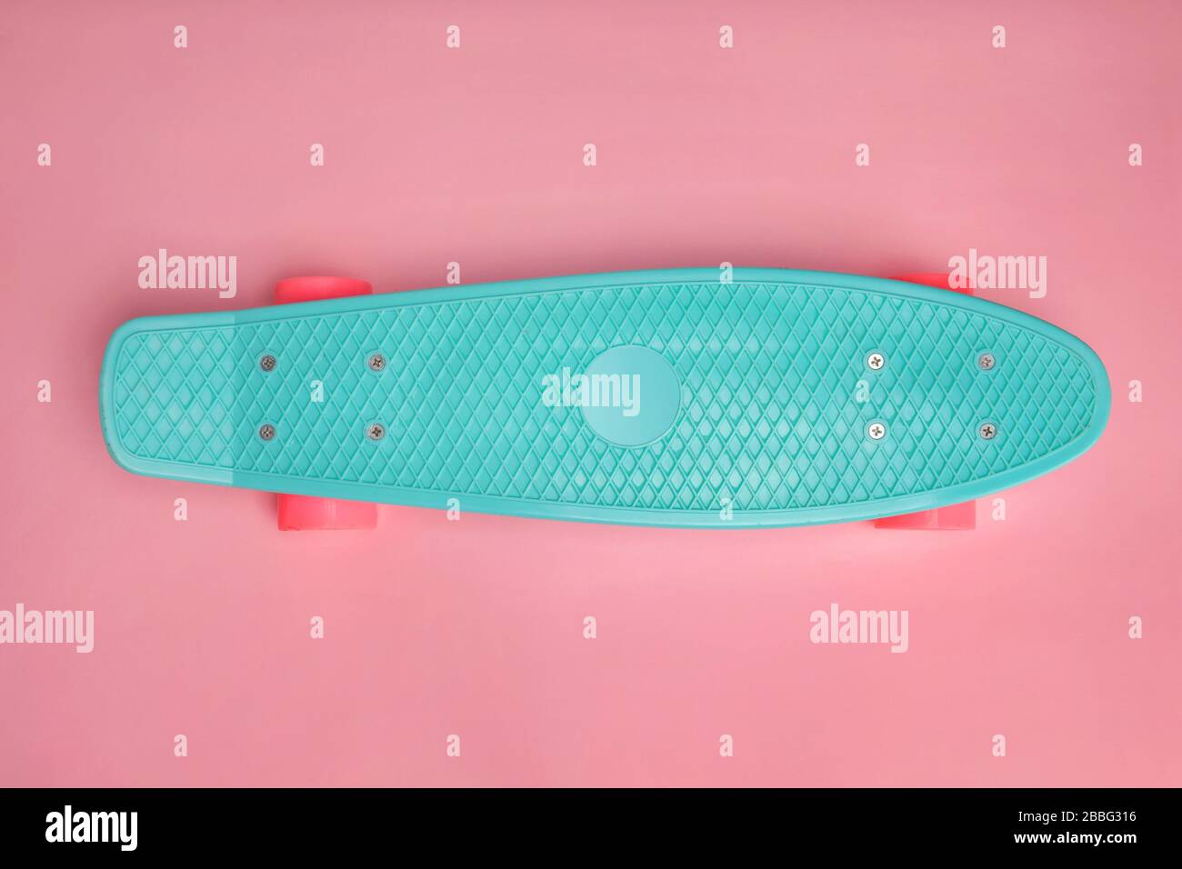 Penny board skate sur fond rose avec espace de copie. Banque D'Images