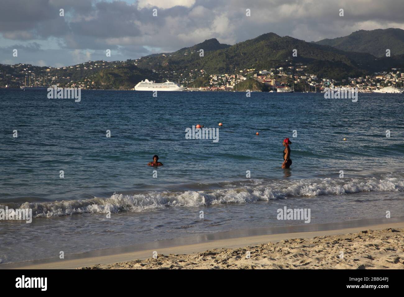 Grenade Grand Anse Beach locaux en mer et bateau de croisière à St Georges en distance Banque D'Images