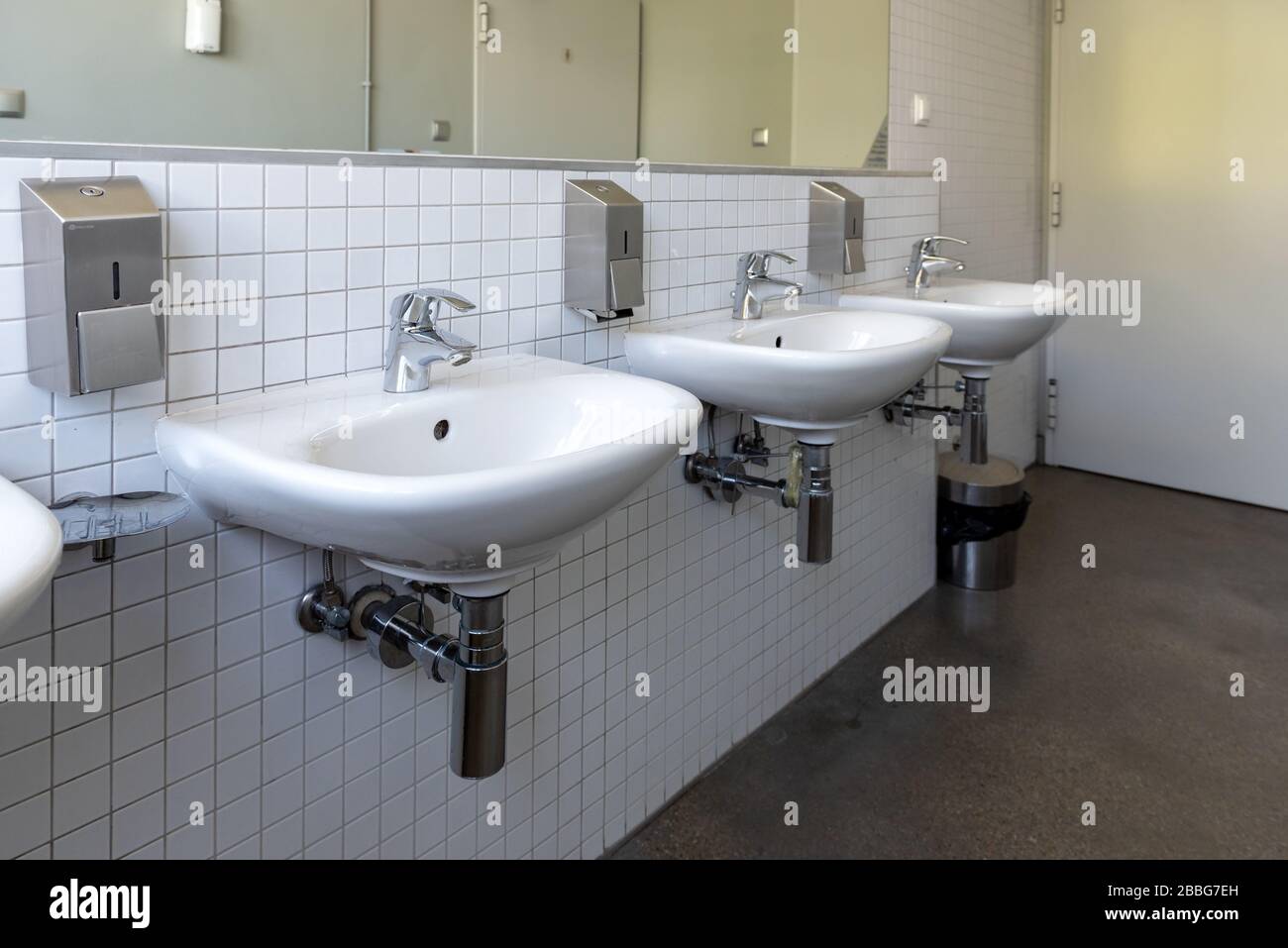 Rangée d'évier en porcelaine blanche dans les toilettes publiques. Concept de protection de l'intégrité antivirus Banque D'Images