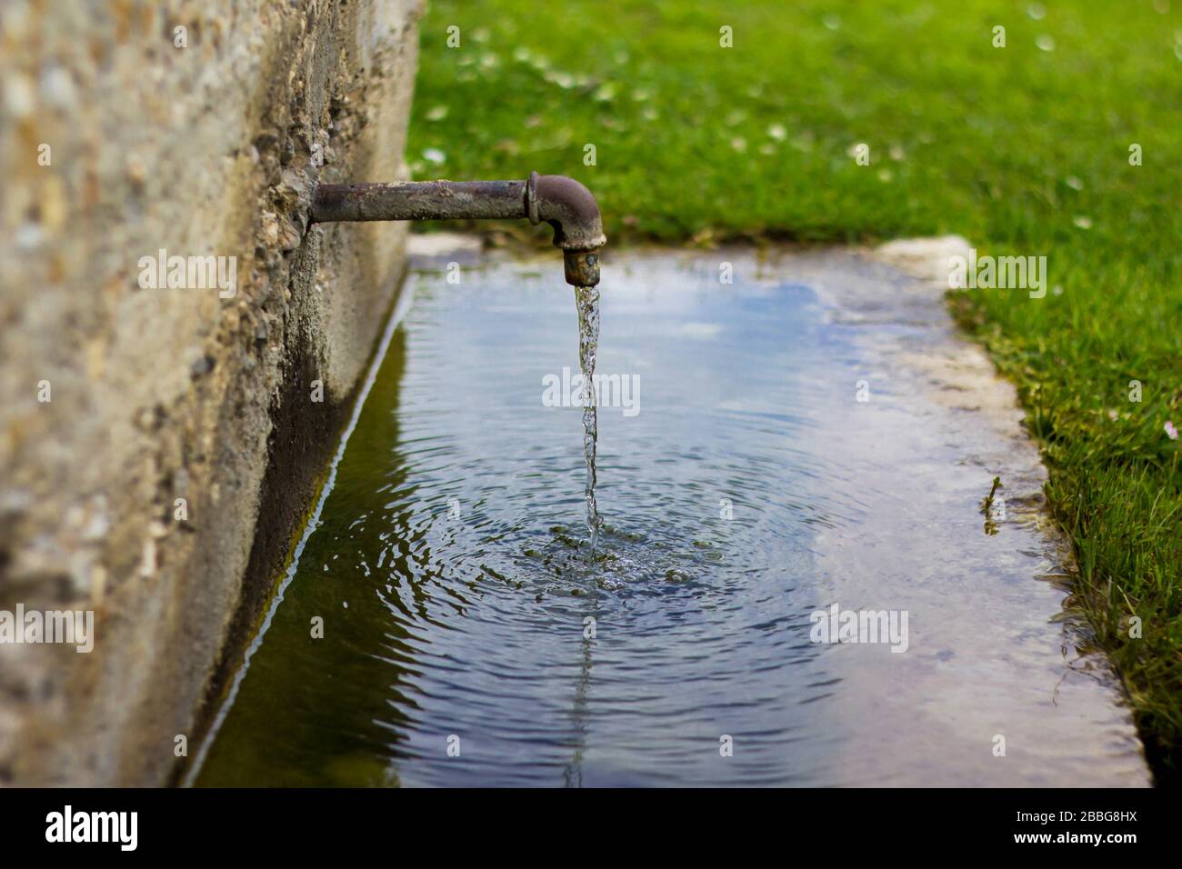 Fontaine d'eau gratuite pour les personnes à l'usage dans la nature. Les robinets d'eau sont trop vieux, probablement du XVIIIe siècle. Il y a des cercles sur le réservoir d'eau. Banque D'Images