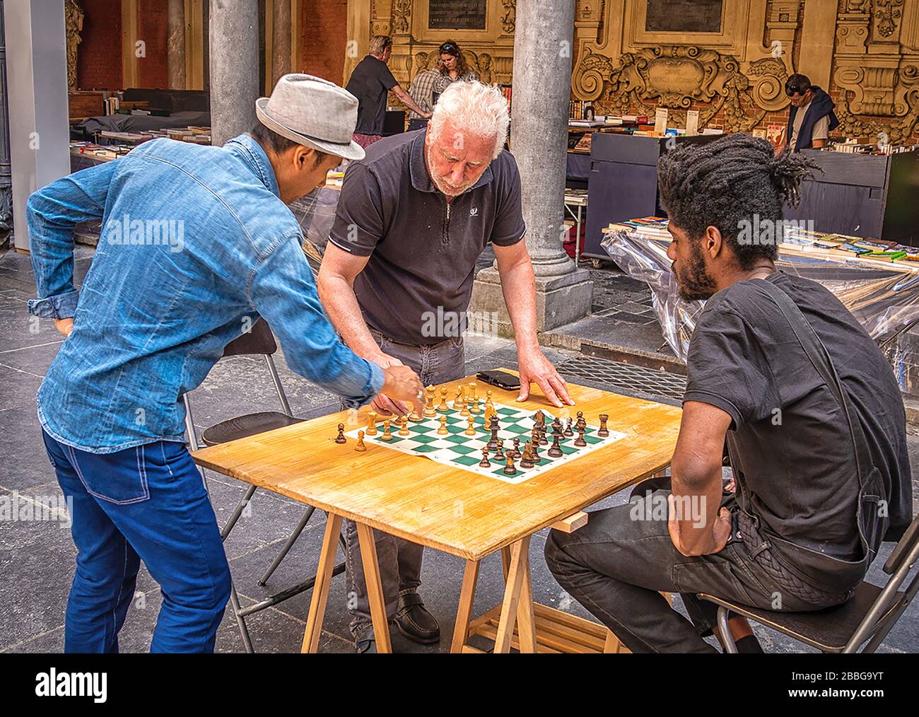 Trois hommes impliqués dans un jeu d'échecs en plein air sur un marché français Banque D'Images