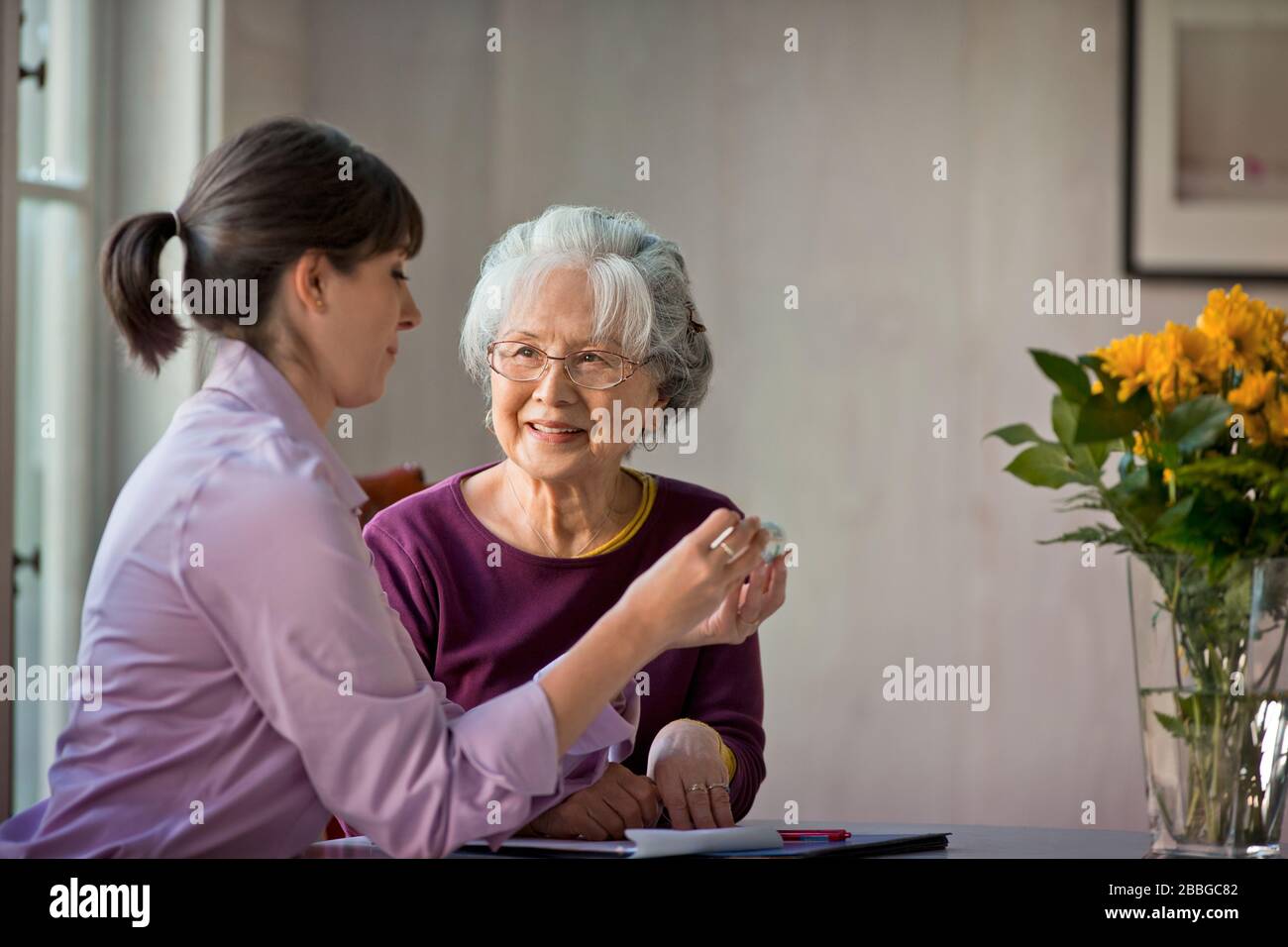 Femme senior parlant avec son soignant des médicaments Banque D'Images