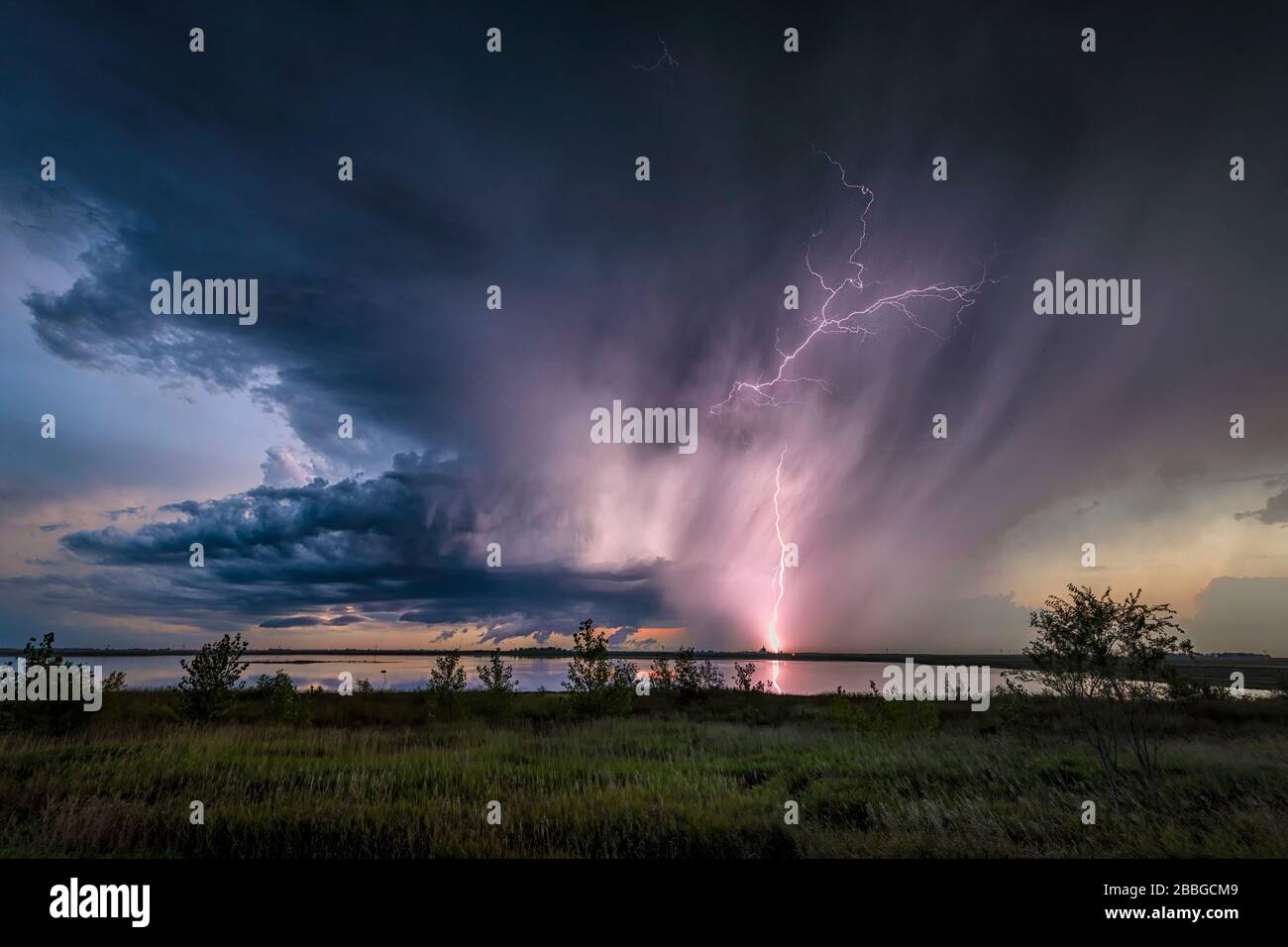 Tempête avec la foudre reflétant hors du lac dans les régions rurales du Dakota du Nord États-Unis Banque D'Images