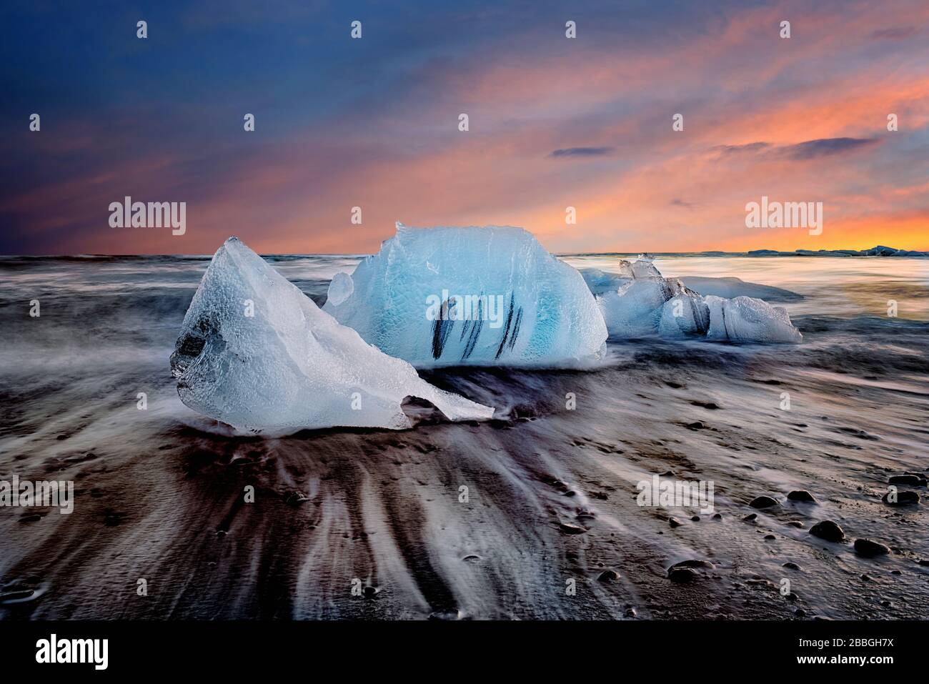 Coucher de soleil sur la plage de sable noir avec glaciers en Islande (image composite) Banque D'Images