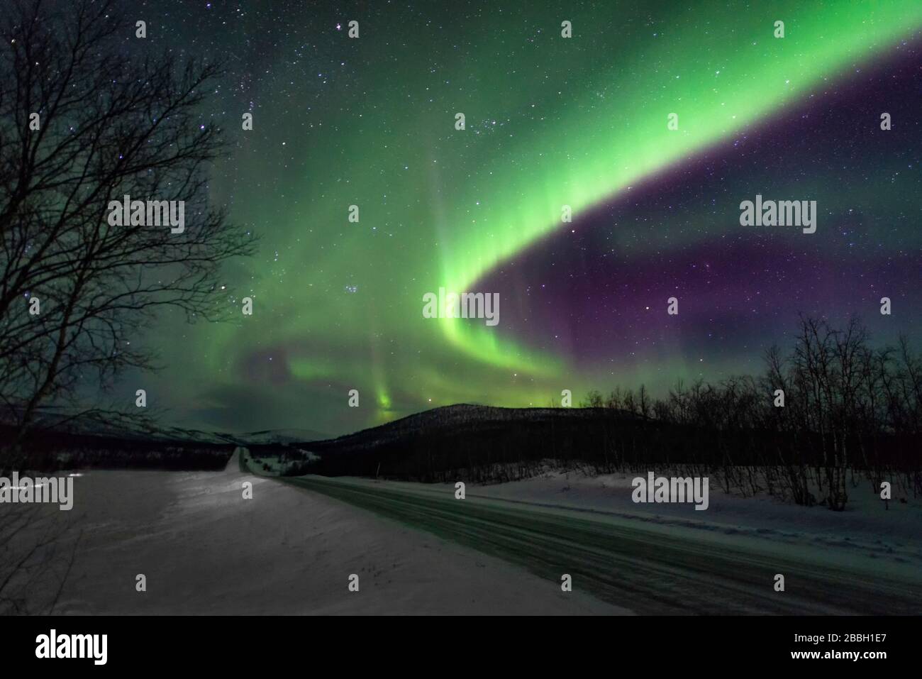 Aurora dansant dans le ciel de Norvège sur les routes d'hiver menant au ciel vert Banque D'Images