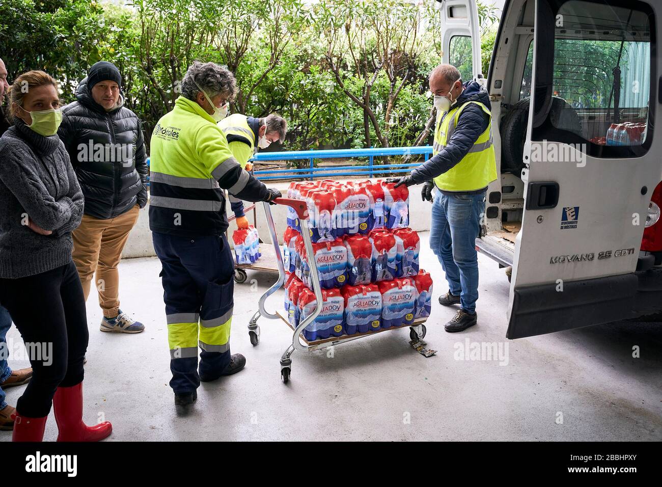 Les hommes de livraison déchargeant l'eau donnée.'Federacion de Penas' de Mostoles donne 4 000 l d'eau minérale à l'hôpital universitaire de Mostoles pour aider à lutter contre la pandémie du virus corona. Banque D'Images