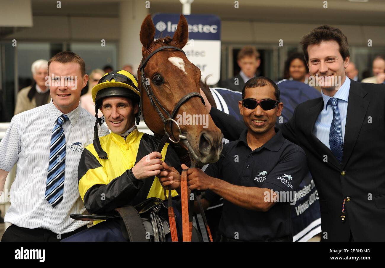 Mirsaale (centre) se tient avec le jockey Neil Callan (2ème à gauche) et le formateur James Tate (à droite) comme ils posent pour une photo après avoir remporté le procès Investec Derby Banque D'Images